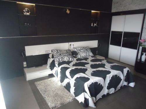 阿尔玛格鲁CASA RURAL LA SUITE DE ALMAGRO的卧室配有黑色和白色的被子。