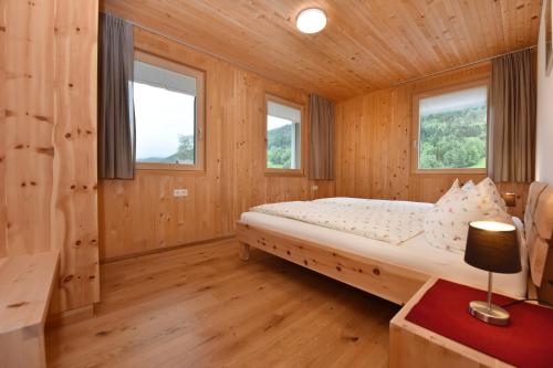 贝曹Ferienhof Felder的小木屋内的卧室,配有床和2扇窗户