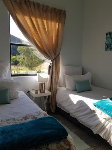 普利登堡湾Matjesfontein Estate Keurbooms Chalet的一间卧室设有两张床和窗户。