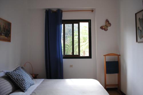 巴列埃尔莫索Hostal Casa Amaya的一间卧室配有一张床和一个带蝴蝶的窗户
