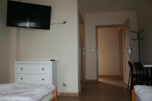 KamienicaArarauna的一间卧室配有一张床和一个墙上的电视梳妆台。
