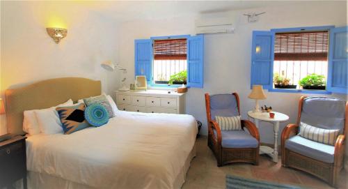 Pinos del ValleCasa del Patio的卧室配有一张床和一张桌子及椅子