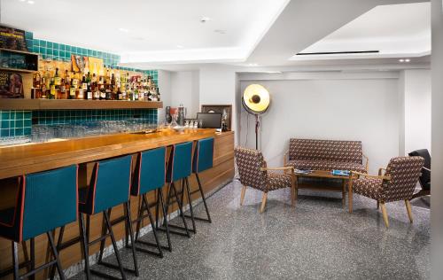 雅典360度流行艺术酒店的一间酒吧,位于带椅子和桌子的房间