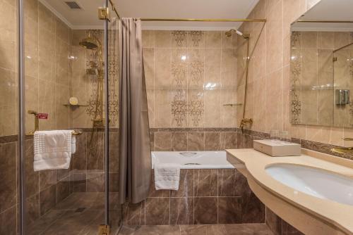 塔什干The Royal Mezbon Hotel & SPA的带浴缸、水槽和淋浴的浴室