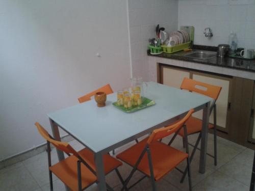 大加那利岛拉斯帕尔马斯华陆酒店的厨房里配有带橙色椅子的桌子