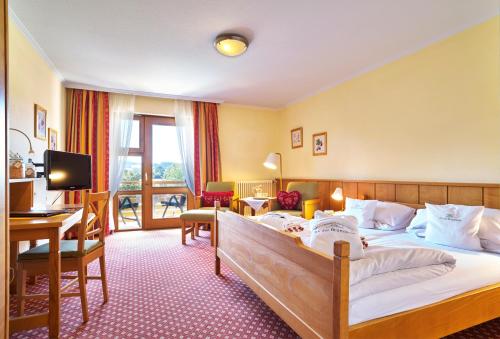 巴特比恩巴赫Hotel An Der Brunnader - Ihr Zuhause im Rottal的配有一张床和一张书桌的酒店客房