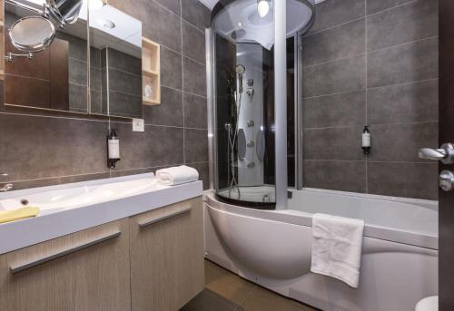 费内-伏尔泰Zenitude Swiss Apparthotels的带浴缸、卫生间和盥洗盆的浴室