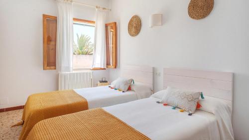卡拉桑塔尼Casa Antonio Sea View的配有2张床的白色墙壁和窗户。