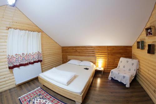 瓦特拉多尔内Cabana Todireni Vatra Dornei的一间小卧室,配有一张床和一把椅子