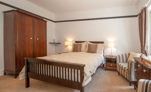 波尔佩罗Natal House Bed & Breakfast的一间卧室配有一张床、一个橱柜和一把椅子