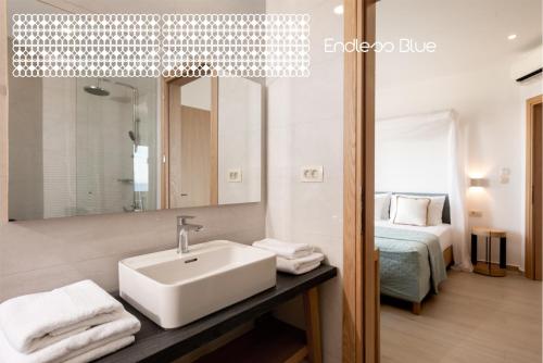 帕琉乔拉Endless Blue的一间带水槽和镜子的浴室以及一张床