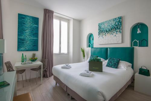 戛纳戛纳欧卡雷克鲁瓦塞特公寓式酒店的一间卧室配有一张大床和一张桌子
