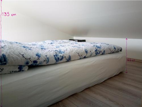 斯蒂克松鲁姆Vatnsás 10的一张带蓝色和白色棉被的床