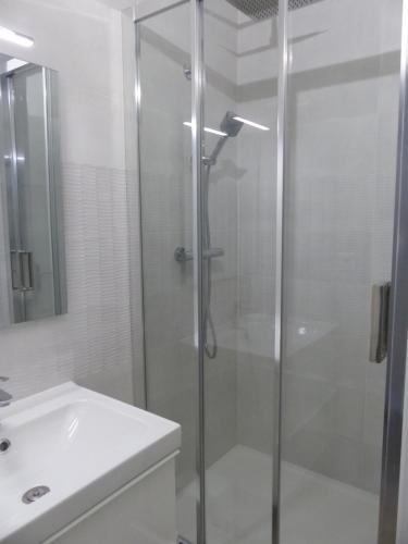 拉罗谢尔Plage des Minimes PONANT 6 VUE MER的一间带玻璃淋浴和水槽的浴室