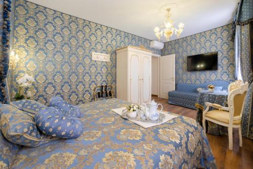 威尼斯Canal View San Marco Luxury Rooms的一间卧室设有蓝色的墙壁和一张带桌子的床