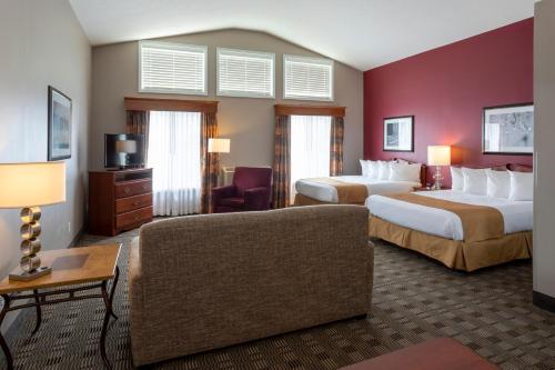 埃姆斯GrandStay Hotel & Suites Ames的酒店客房,设有两张床和一张沙发