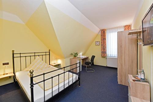 格拉德贝克霍斯凯梦瑞酒店的一间卧室配有一张床、一张书桌和一个窗户。