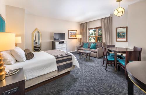 圣地亚哥WorldMark San Diego - Balboa Park的酒店客房带一张床、一张桌子和椅子