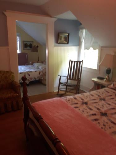 Stayner加不勒斯住宿加早餐酒店的一间卧室,卧室内配有一张床和一把椅子