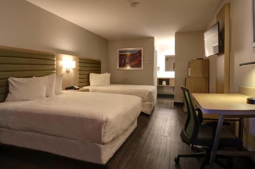 弗拉格斯塔夫格林豪泰弗拉格斯塔夫酒店的酒店客房设有两张床和一张桌子。