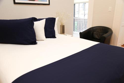 波士顿Comfy Beacon Hill Studio Great for Work Travel #7的一间卧室配有一张带蓝色枕头的床和一把椅子