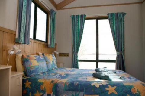 图洛斯海德Tuross Lakeside Holiday Park的一间卧室设有一张床和一个窗口