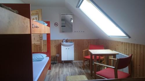 Myza IgasteWorld's End Hostel的客房设有床、桌子和窗户。