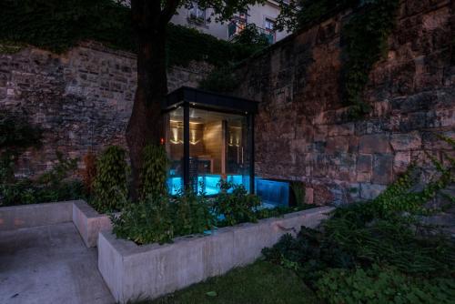 布达佩斯Castle Apartments Budapest的砖墙中带游泳池的玻璃房子