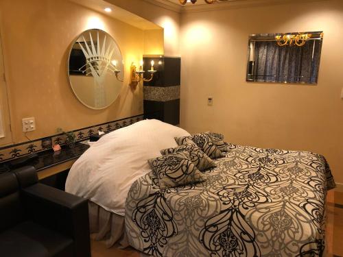 长崎长崎小型俱乐部情趣酒店（仅限成人）的一间卧室配有一张床和镜子