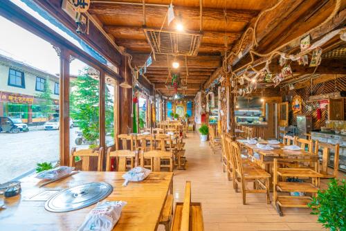 香格里拉香格里拉古城远方的家客栈的餐厅设有木桌和木椅