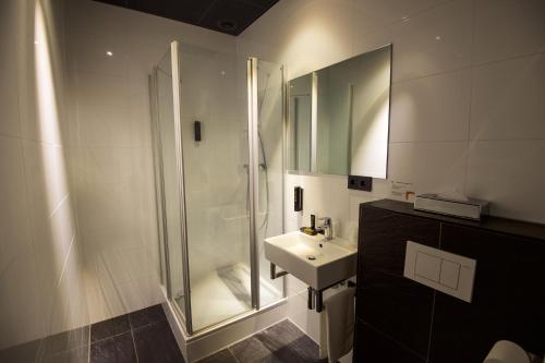 埃因霍温光辉设计酒店的带淋浴和盥洗盆的浴室