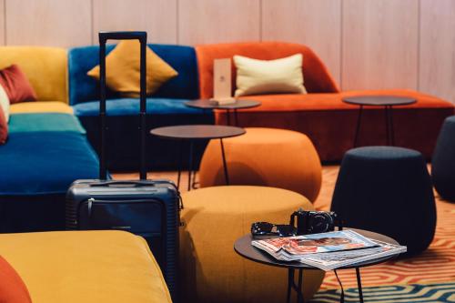哥本哈根ProfilHotels Richmond的一间设有色彩缤纷的家具和一张带摄像头的桌子的房间