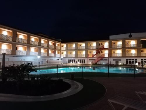 德尔锡伦西奥海岸Apartamentos Parque Carolina的一座大型建筑,晚上设有游泳池