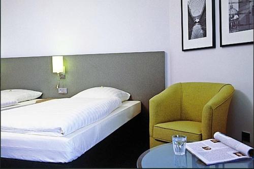 克尔彭ABZ欧文奈特塔格昂斯酒店的一间卧室配有一张床、一把椅子和一张桌子