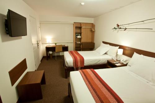 利马米拉弗洛雷斯拉尔科大地生活酒店的酒店客房设有两张床和电视。