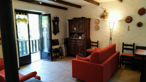普拉吉拉托La Segheria的客厅配有红色的沙发和桌子