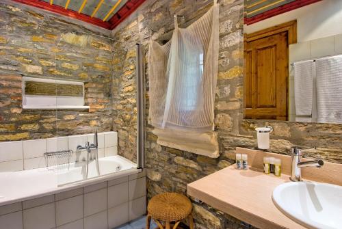 安吉斯乔治亚斯尼拉阿诺瓦利奥斯精品酒店的带浴缸和水槽的石质浴室