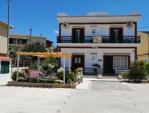 科孚镇Luna Bianca - Corfu Apartments的白色的房子,配有遮阳伞和庭院