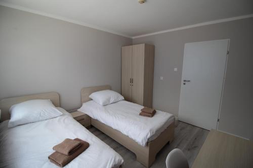 BrzeziePod Kominem Pokoje i Apartamenty的一间卧室配有两张带毛巾的床