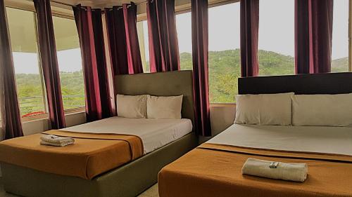 瓦加蒙Vagamon Clouds的带窗户的酒店客房内的两张床
