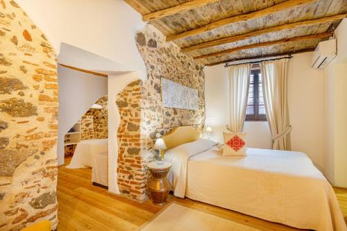 奥罗塞伊阿尔伯格迪弗索曼诺斯酒店的一间卧室设有两张床和石墙