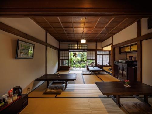 大津Inase Otsu Machiya Bed and Breakfast的一间带木桌的客厅和一间厨房