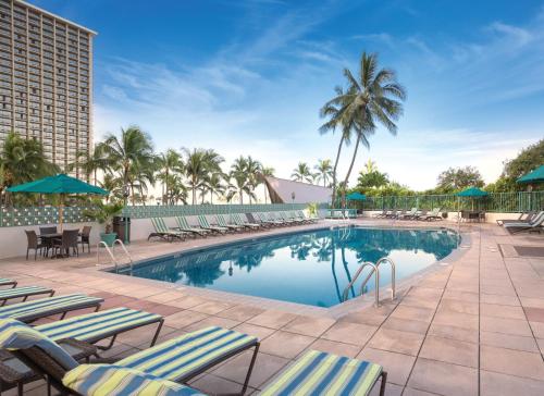 檀香山伊利凯威基基滨海度假酒店的一个带躺椅的游泳池和一间酒店