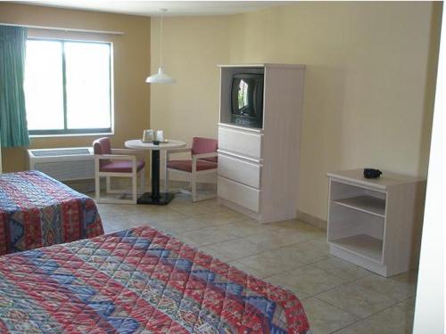 迈阿密迈阿密公主酒店的一间酒店客房,配有一张床、一台电视和一张桌子
