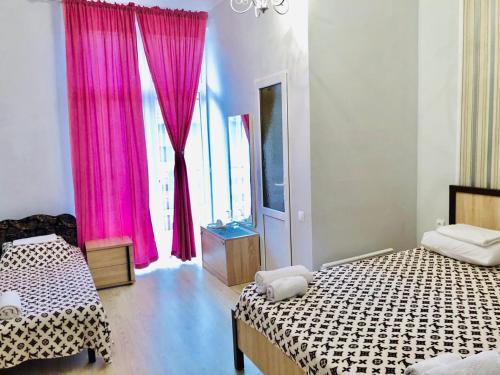 苏呼米约莫尔亚旅馆的一间卧室配有两张床和粉红色窗帘