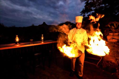 埃祖尔韦尼蒙特佳酒店的厨师在烧烤炉前的火上行走