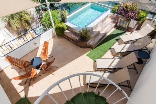 普拉亚卡门科拉松套房酒店的享有带椅子和桌子的游泳池的顶部景致