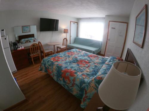 威尔伍德克拉斯特Sea Chest Motel Dot Com for Deals!的卧室配有1张床、1张桌子和1把椅子