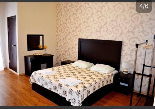 苏呼米约莫尔亚旅馆的一间卧室配有一张黑色床头板的床