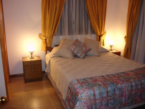 安加罗阿Turismo Vinapu的一间卧室配有一张带两盏灯的床。